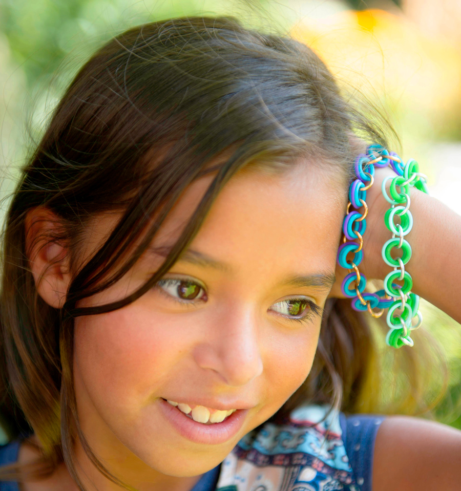 Girl wearing friendship bracelets in blue, purple and green by Linkt Crafts Kits