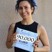 Rebeca Mojica holding package, a graphic with the number 90,000 is superimposed on the package