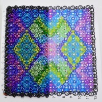 partially created chainmaille quilt square laid over a pattern guide