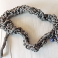 tightly woven and knotted gnarly attempt at crochet made with thick gray yarn