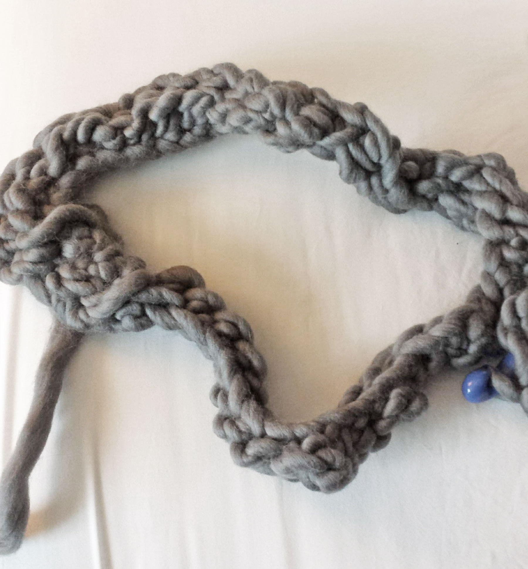 tightly woven and knotted gnarly attempt at crochet made with thick gray yarn