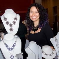 rebeca mojica standing next to her jewelry displays